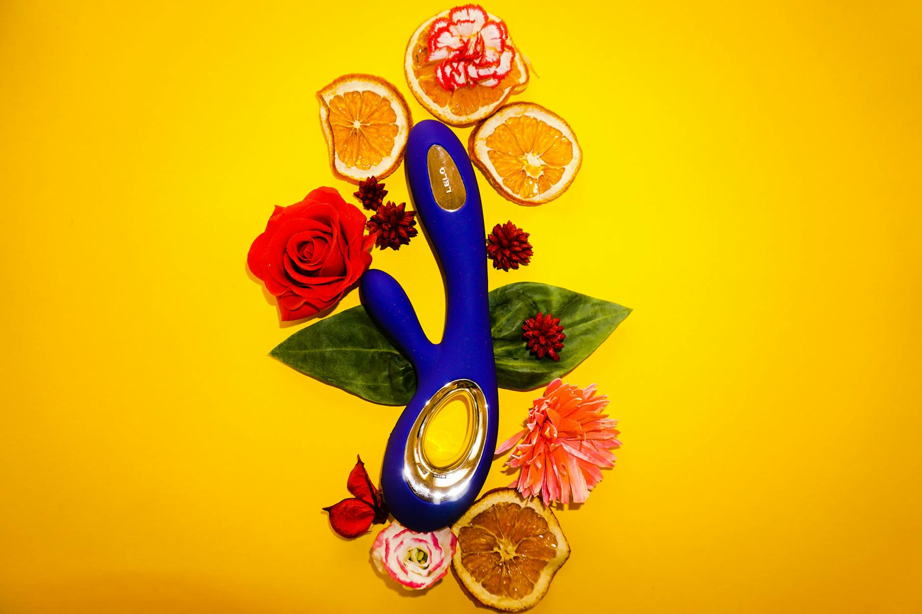 Vibrators arranged on yellow surface with flowers